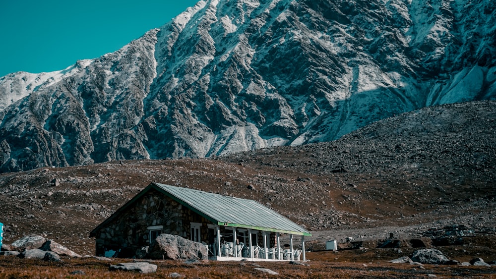 white and gray wooden house near gray mountain during daytime