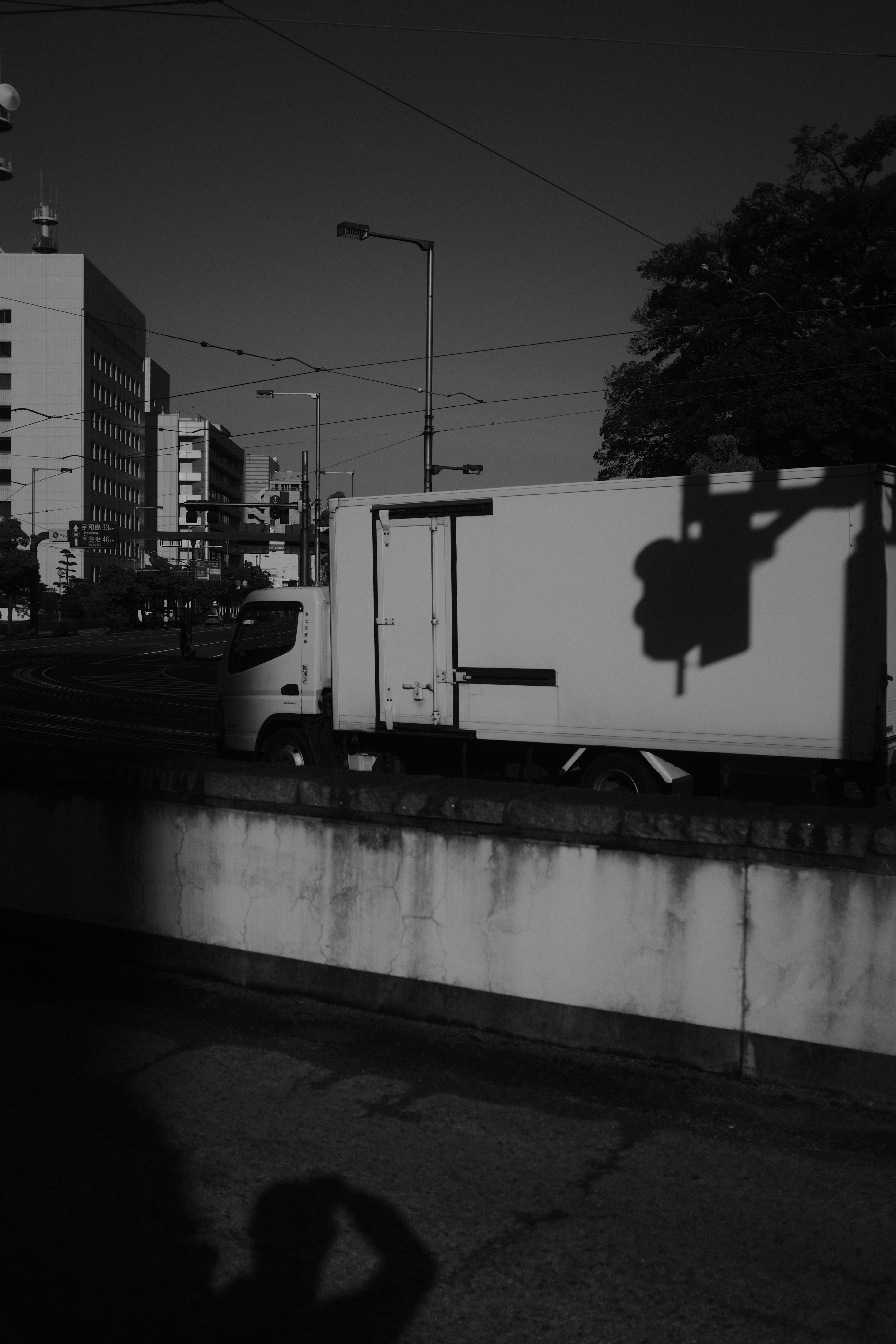 grayscale photo of white truck on road