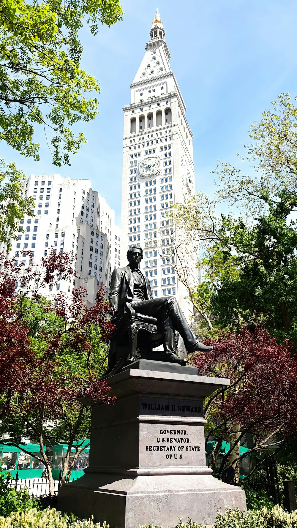 Statua seduta dell'uomo vicino all'edificio in cemento bianco durante il giorno