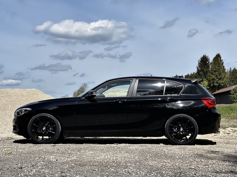 black sedan on gray asphalt road under blue and white sunny cloudy sky during daytime