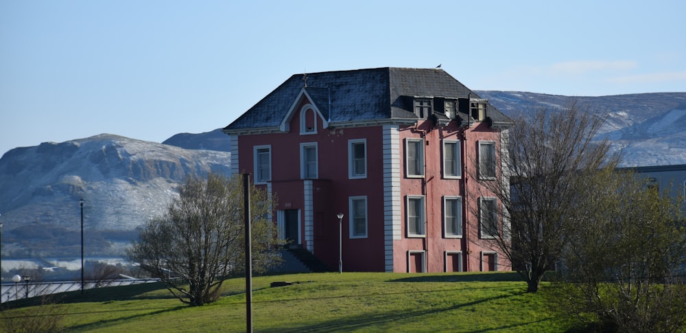 Bâtiment en béton brun et blanc près d’un champ d’herbe verte pendant la journée