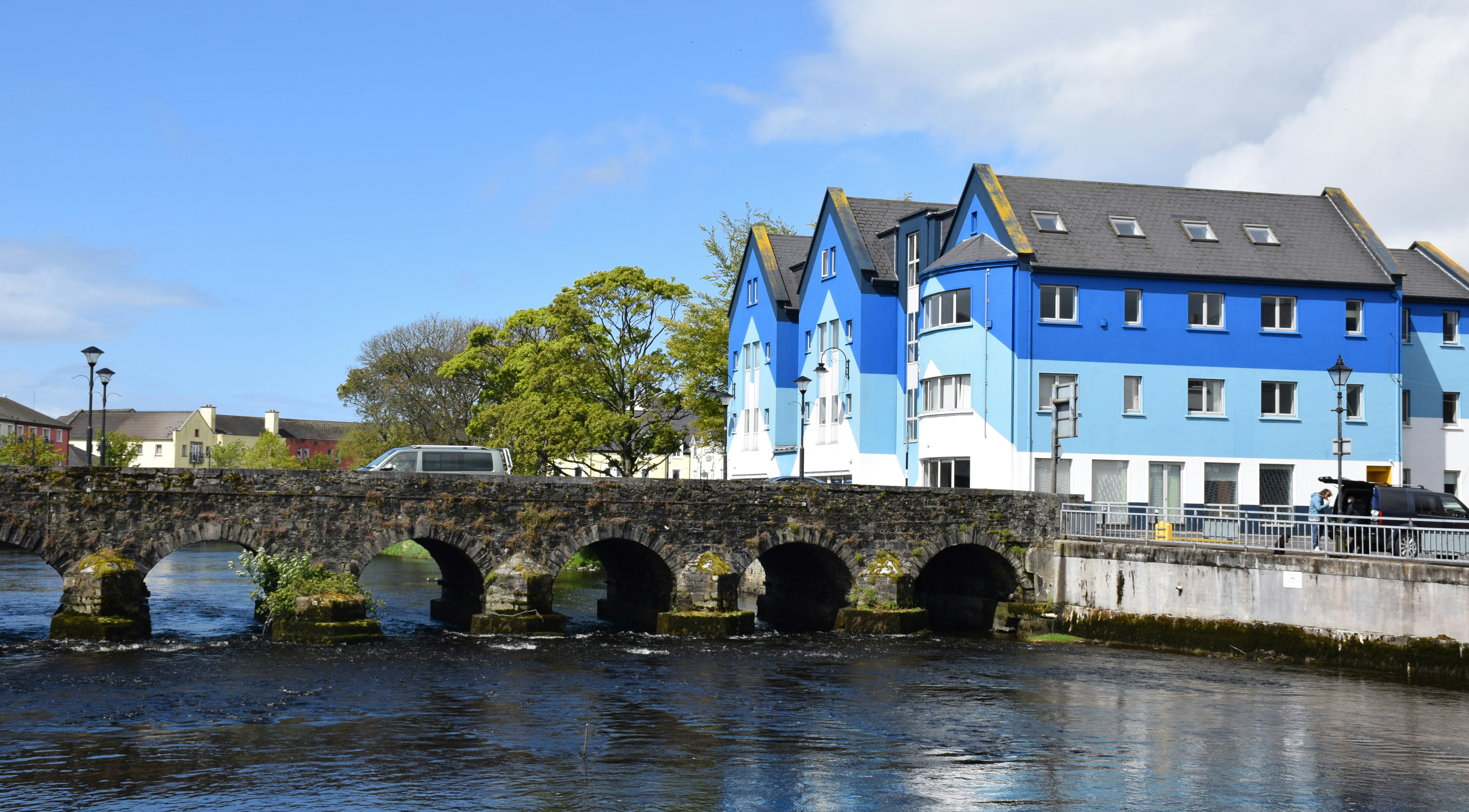 white and blue concrete building beside river during daytime