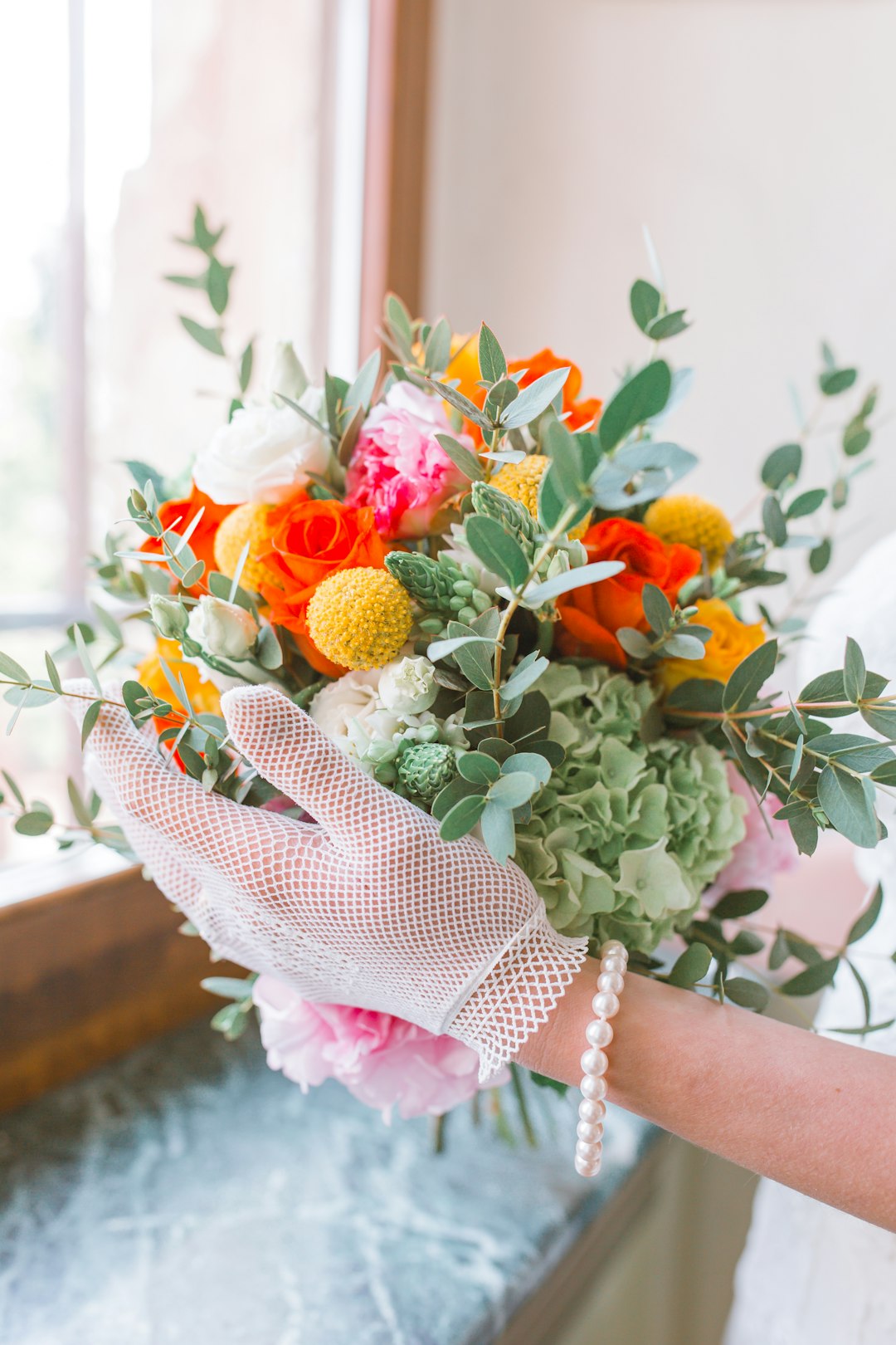 person holding orange and yellow flowers