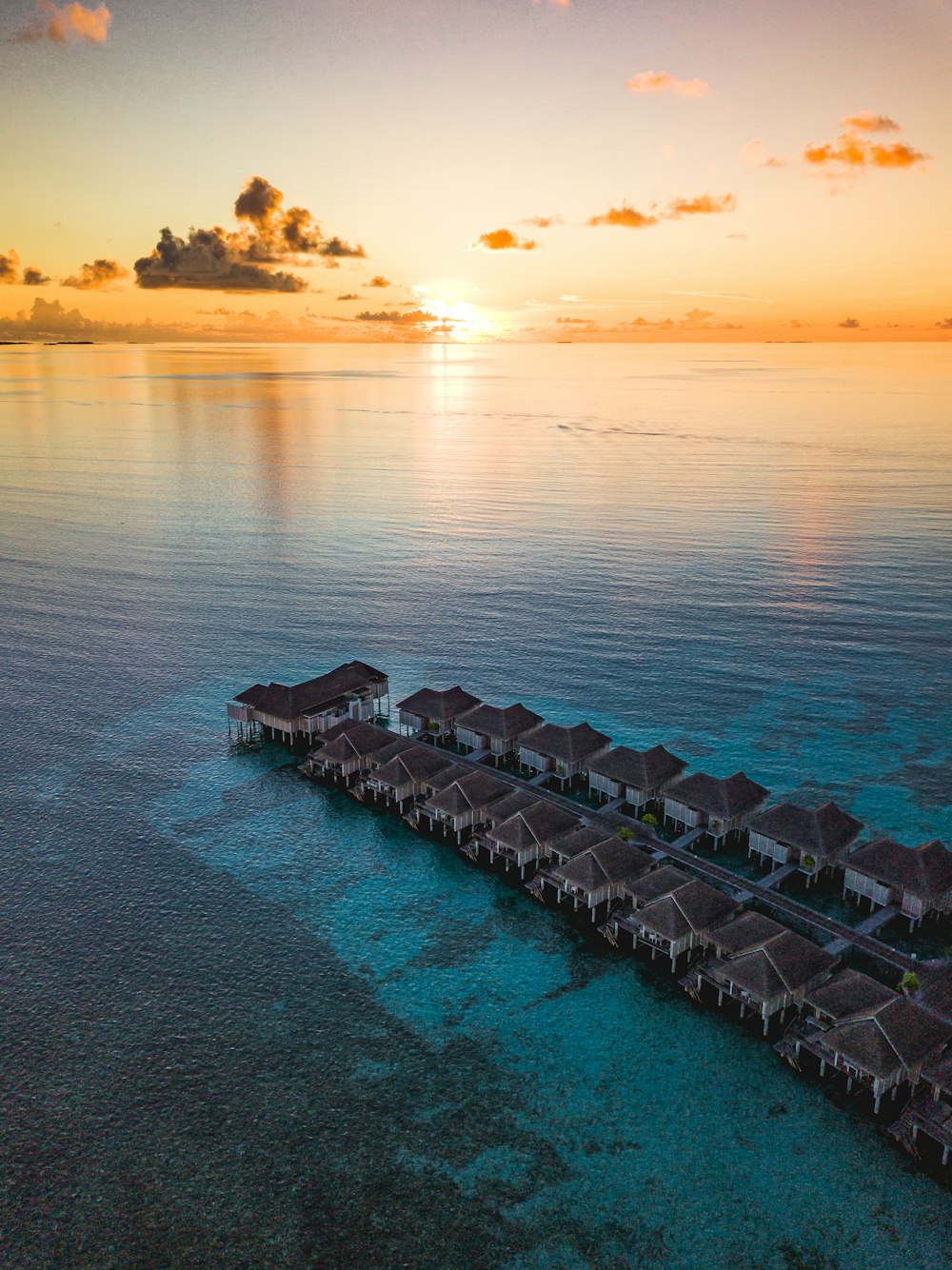 gray concrete dock on body of water during sunset