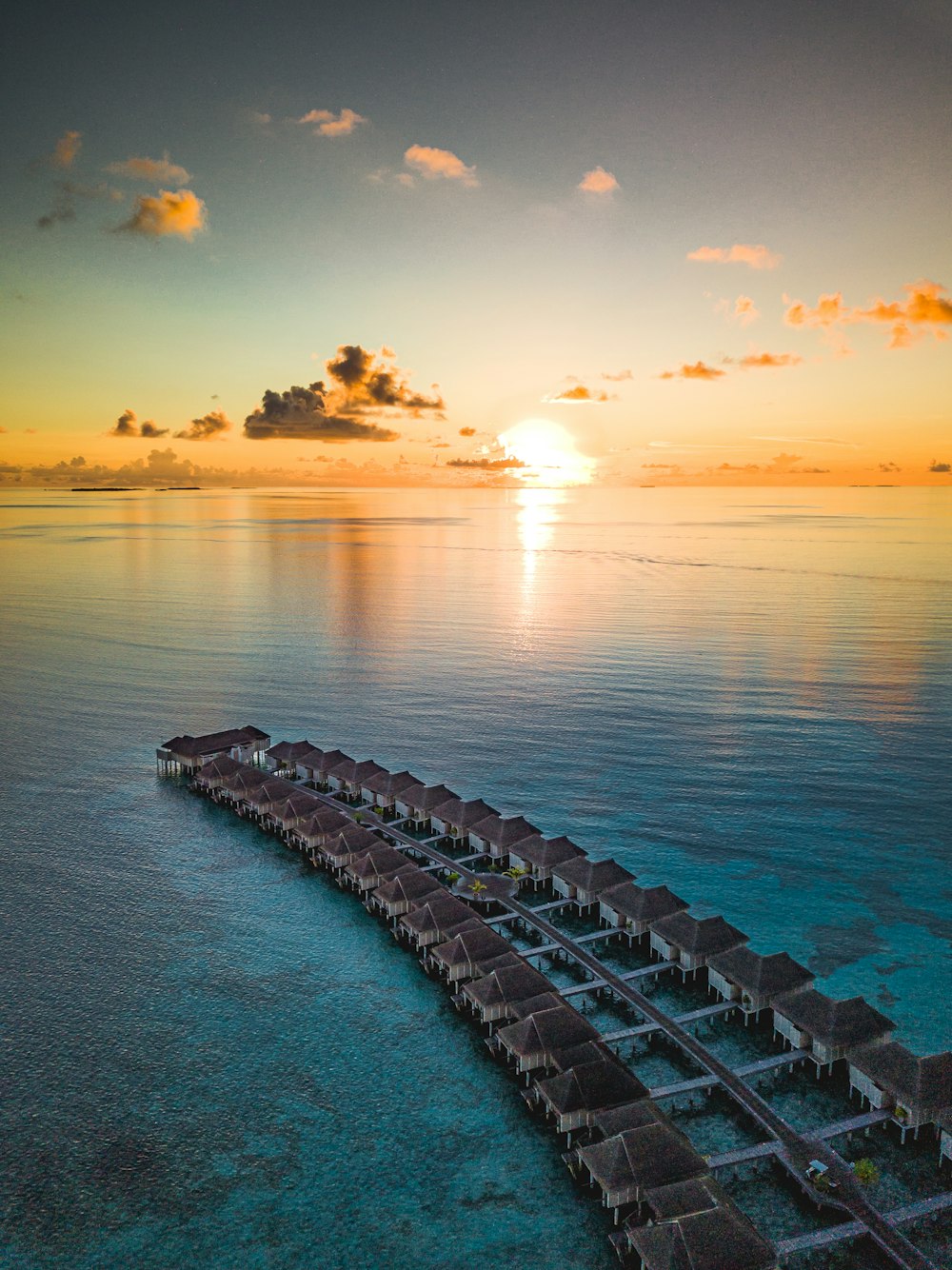 gray concrete dock on sea during sunset