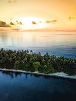 A serene sunset over a tropical island, part of a travel package by Voandosky Ltda.