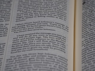 An open book displaying printed text in English. The text appears to be a passage from a religious or historical text, focusing on a conversation between Hiram and Solomon. The book is open to reveal two pages with a paragraph highlighted in some manner.