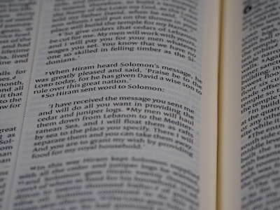 An open book displaying printed text in English. The text appears to be a passage from a religious or historical text, focusing on a conversation between Hiram and Solomon. The book is open to reveal two pages with a paragraph highlighted in some manner.