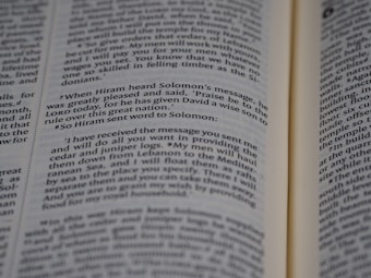 An open book displaying printed text in English. The text appears to be a passage from a religious or historical text, focusing on a conversation between Hiram and Solomon. The book is open to reveal two pages with a paragraph highlighted in some manner.