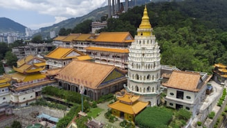 white and brown concrete building near green trees during daytime
