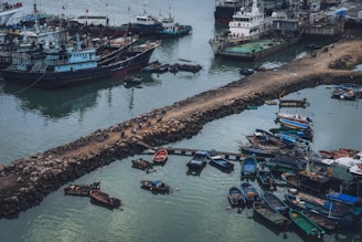 Drone flying over a busy port with ships docked, capturing vibrant aerial photos.