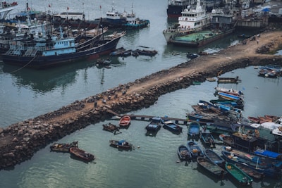 Drone flying over a busy port with ships docked, capturing vibrant aerial photos.
