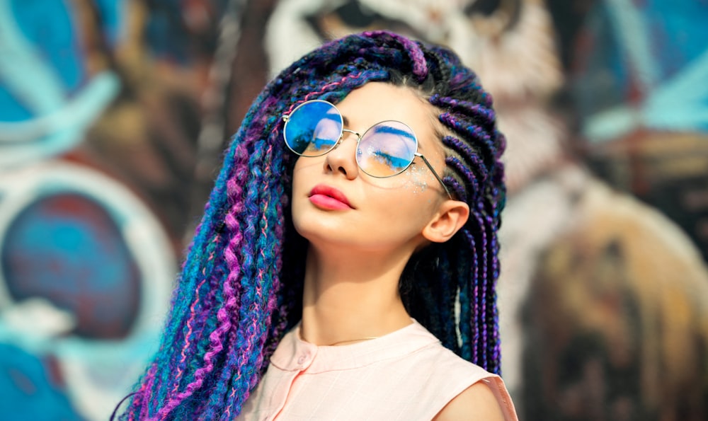 woman in white tank top wearing blue framed sunglasses