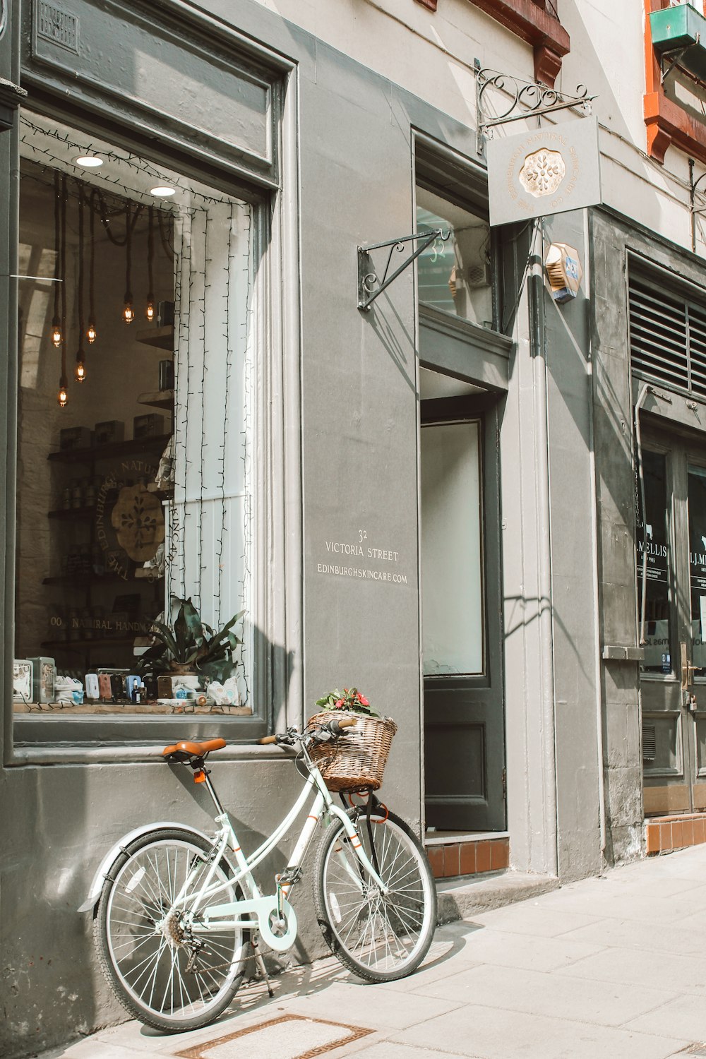 white city bike parked beside store