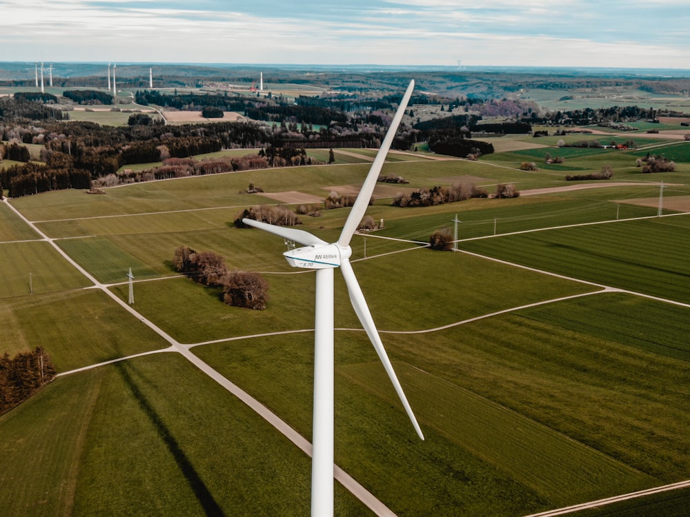 white wind turbine on green grass field during daytime