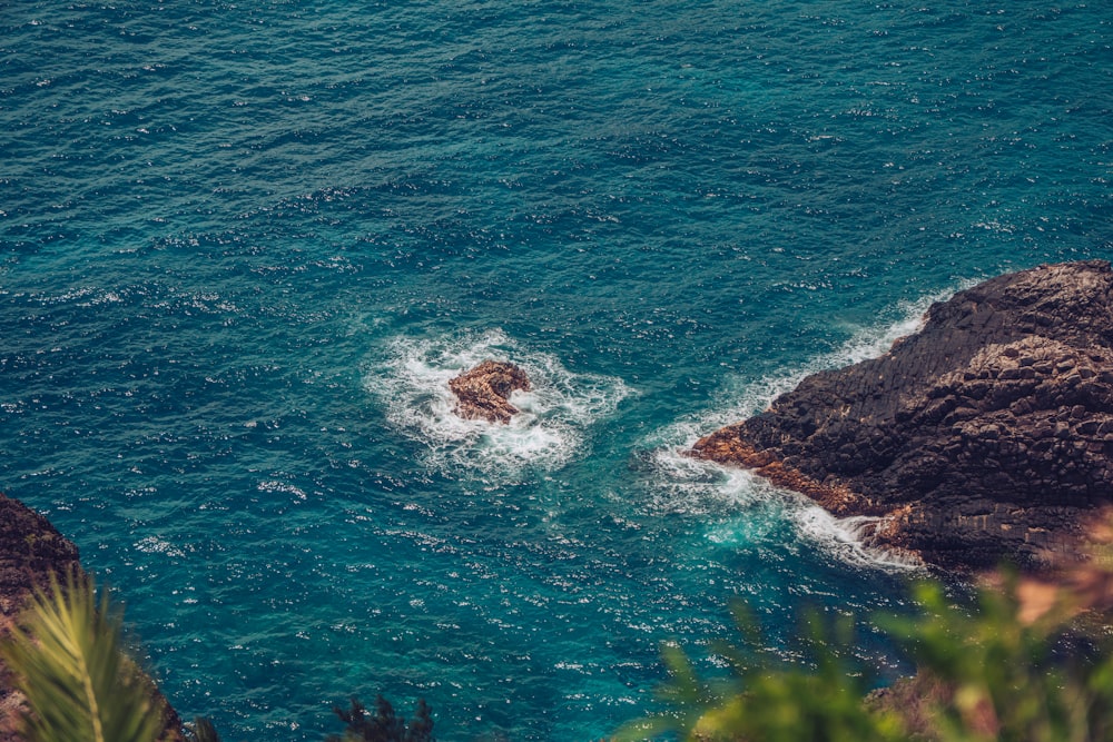 a body of water surrounded by rocks and greenery