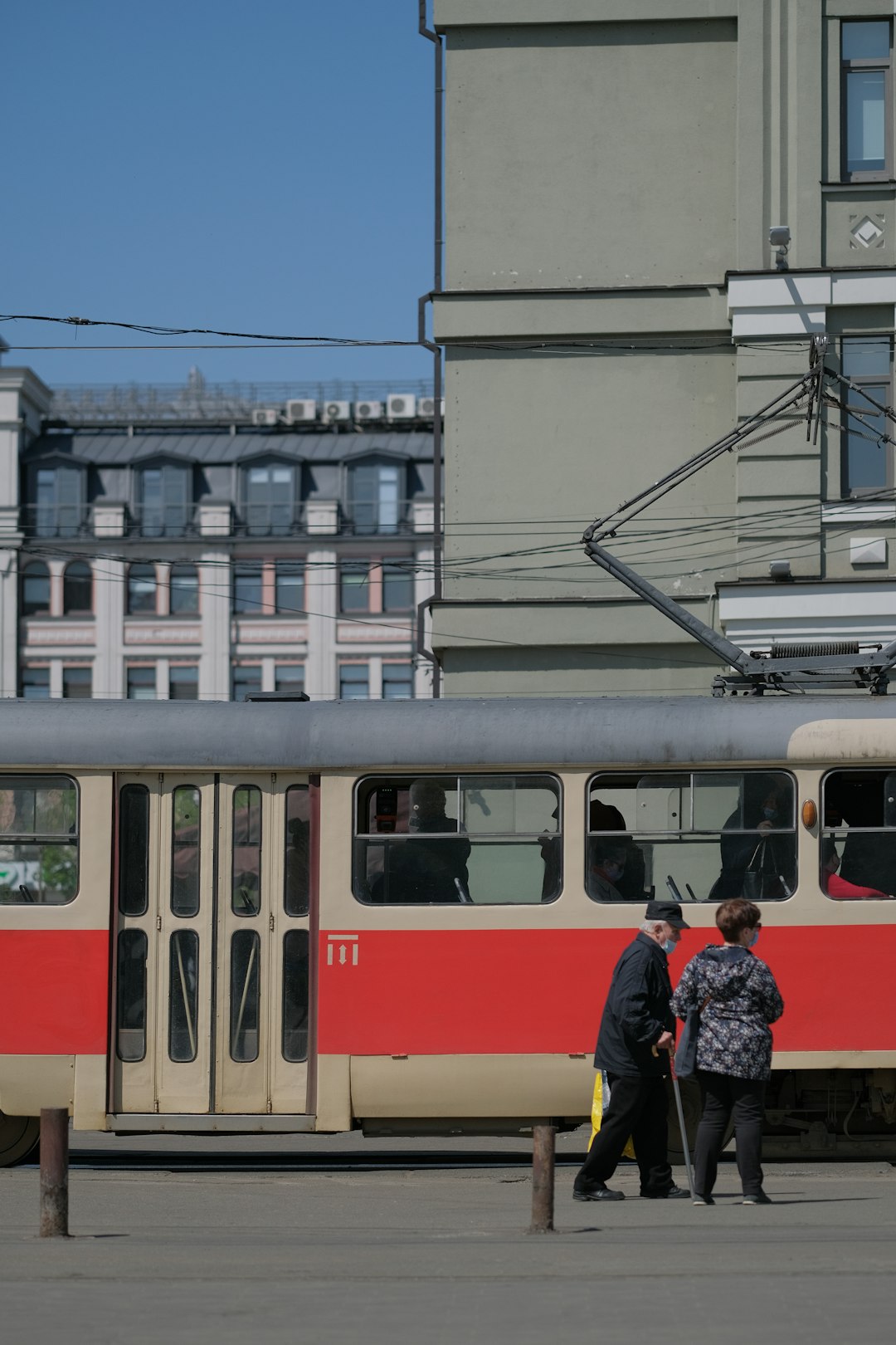 red and white train on rail road near building during daytime