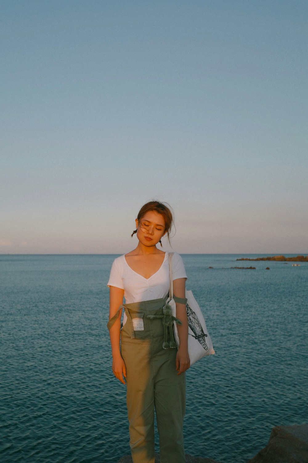 woman in white and brown dress standing on seashore during daytime