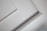 A close-up view of an interior ceiling corner with decorative molding. The light gray color of the wall contrasts slightly with the white trim, creating a subtle geometric pattern.