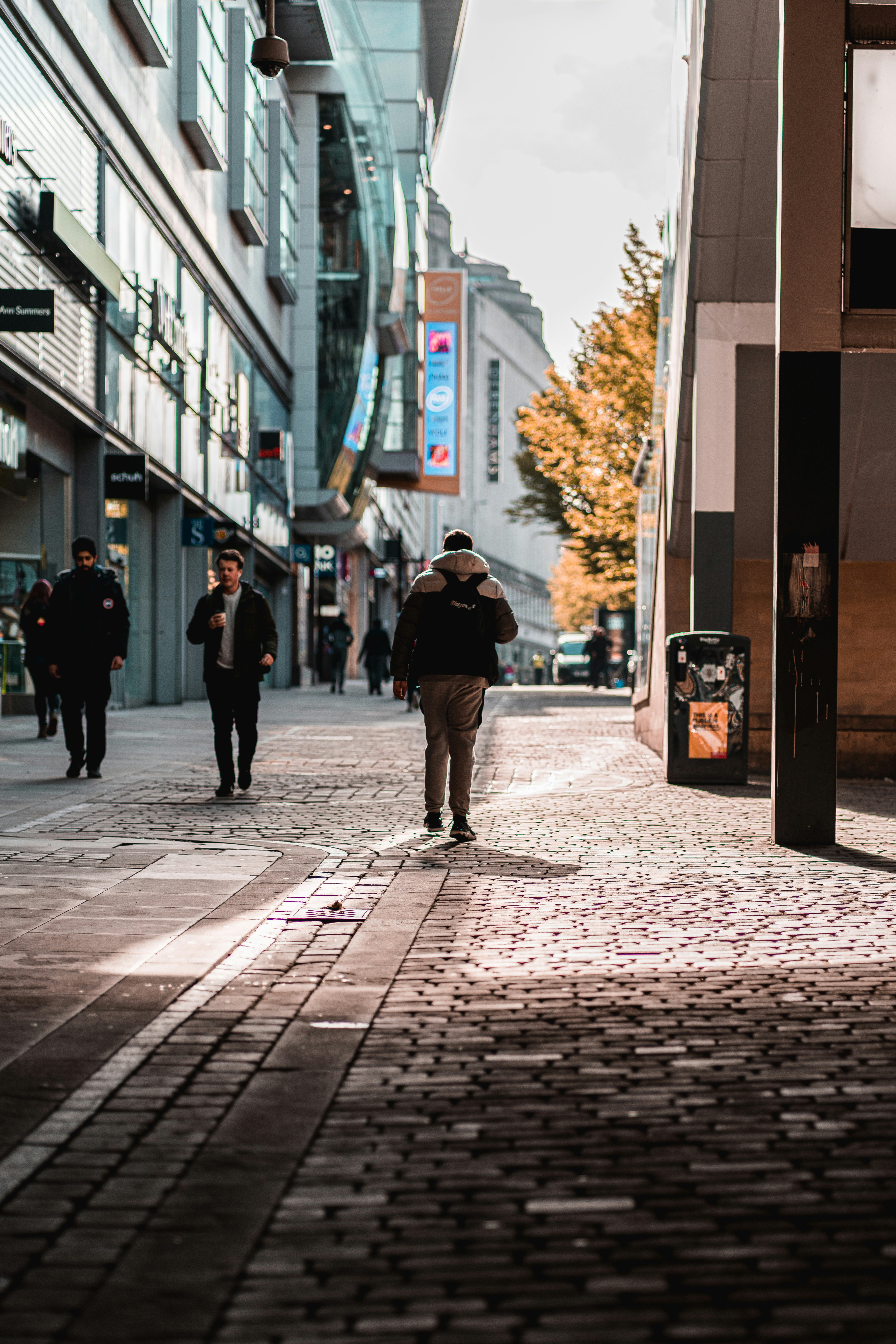 man in black jacket walking on sidewalk during daytime