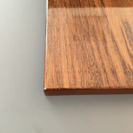 Close-up of the desk’s smooth surface showing fine wood grain and clean edges.