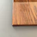 Close-up of smooth birch wood grain on a minimalist coffee table with subtle matte finish.