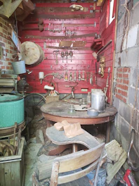 A rustic workshop corner filled with vintage scrap materials and partially assembled art pieces.