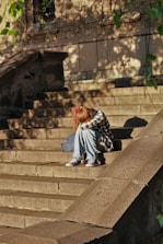 woman in black and white dress sitting on concrete stairs