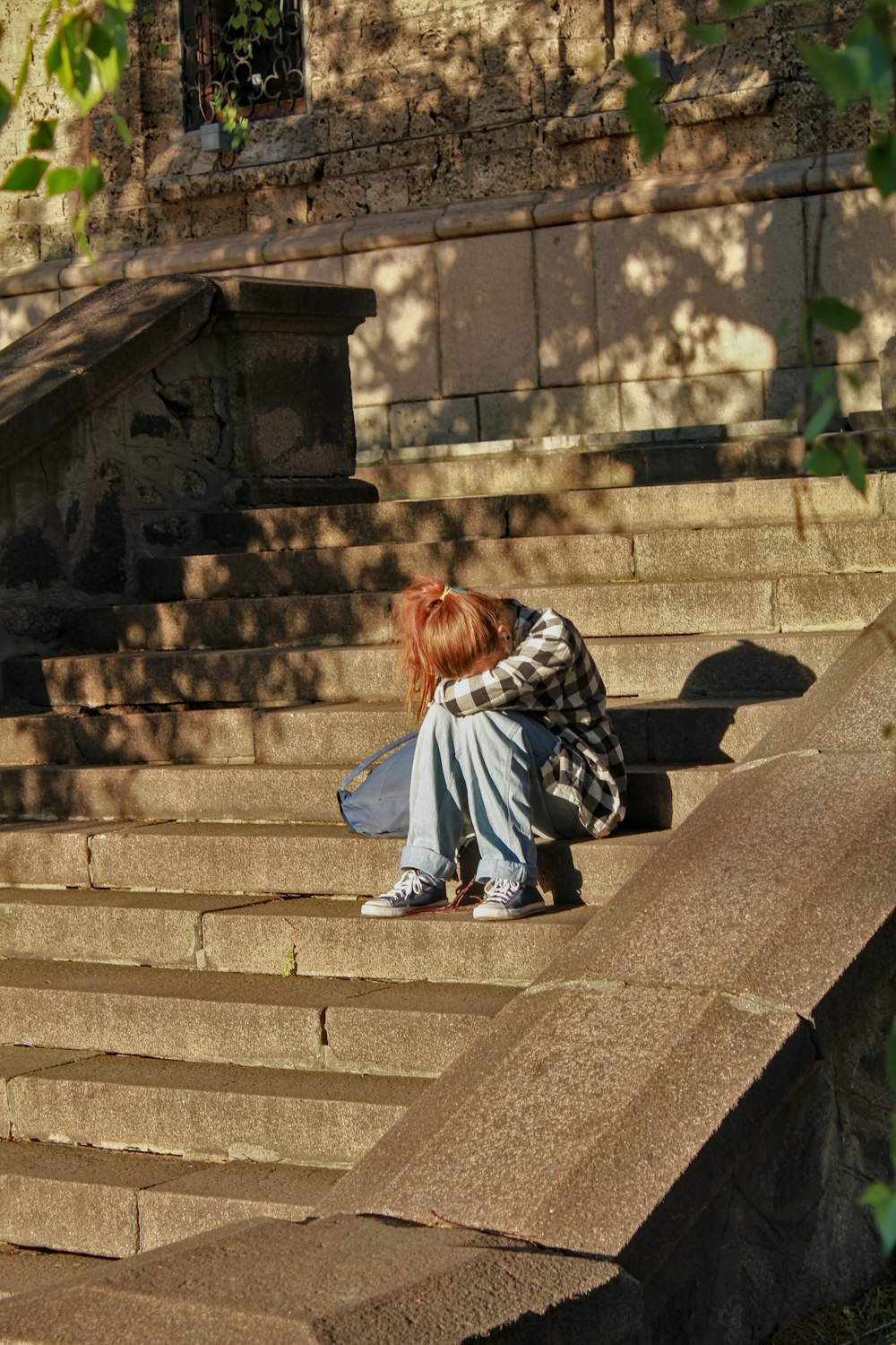 Femme en robe noire et blanche assise sur des escaliers en béton