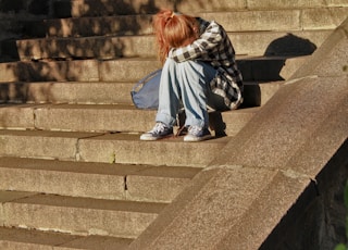 woman in black and white dress sitting on concrete stairs