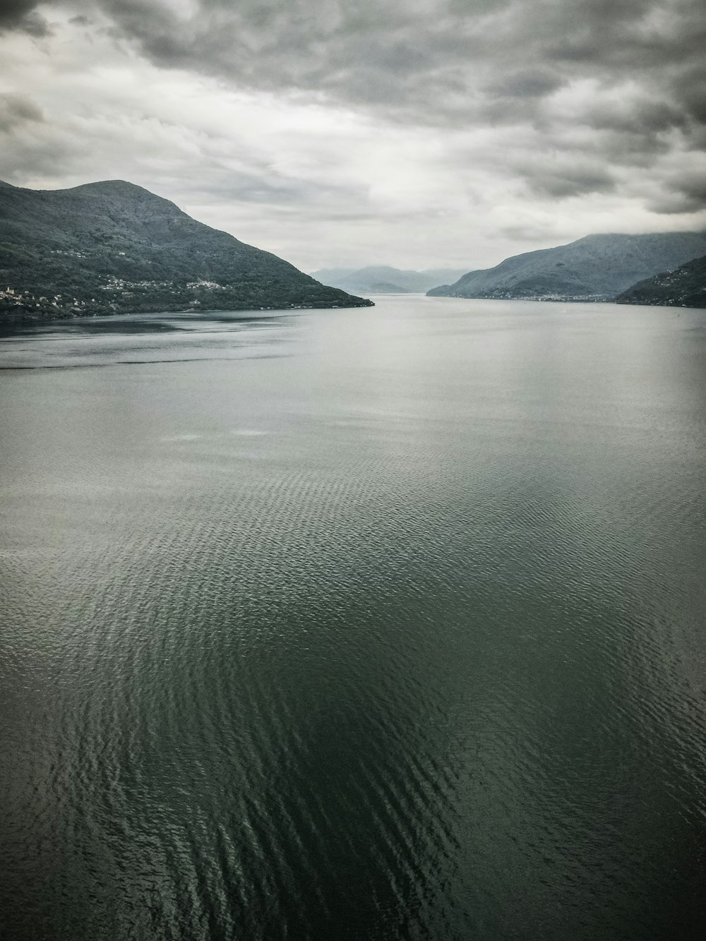 body of water near mountain during daytime