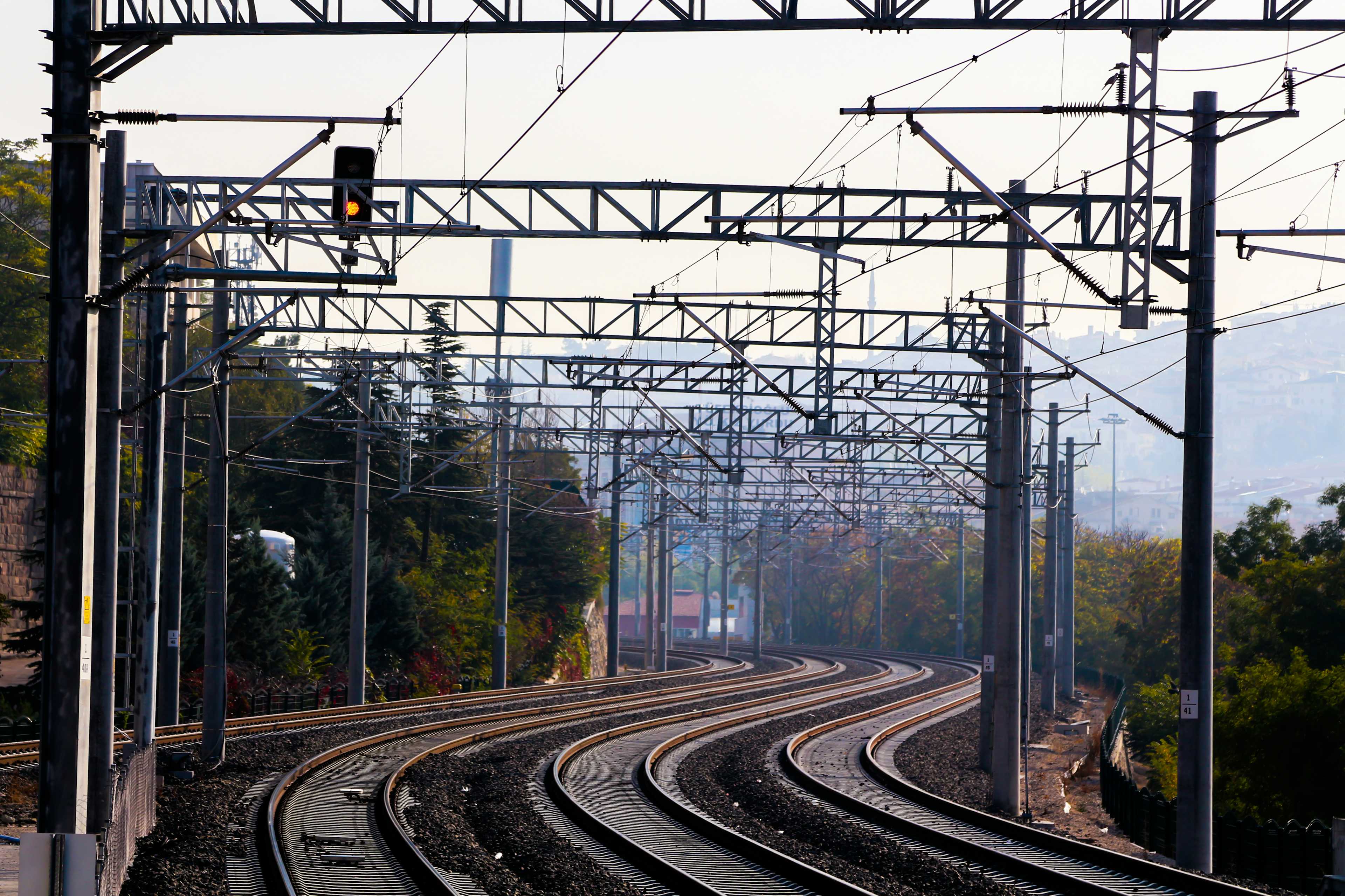 train rail tracks near trees during daytime