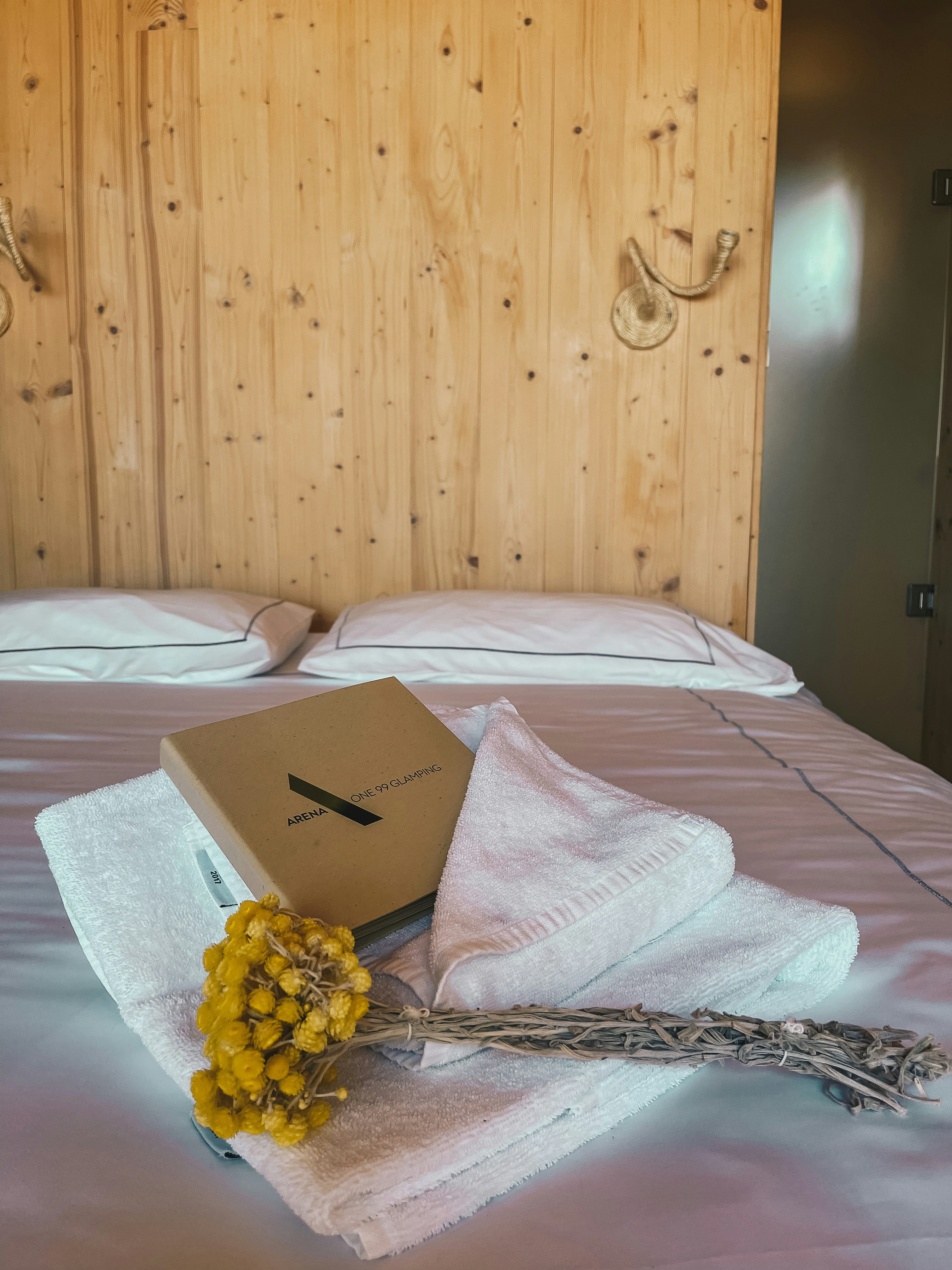Beautifully made hotel-style bed with white linens, fresh towels, spotless clean vacation rental room