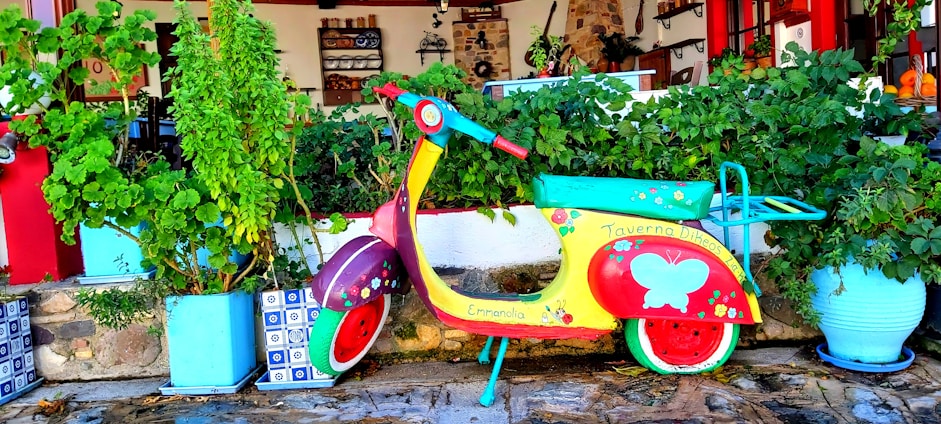 A vibrant photo of a kukirin scooter parked beside a colorful city mural on a sunny day.