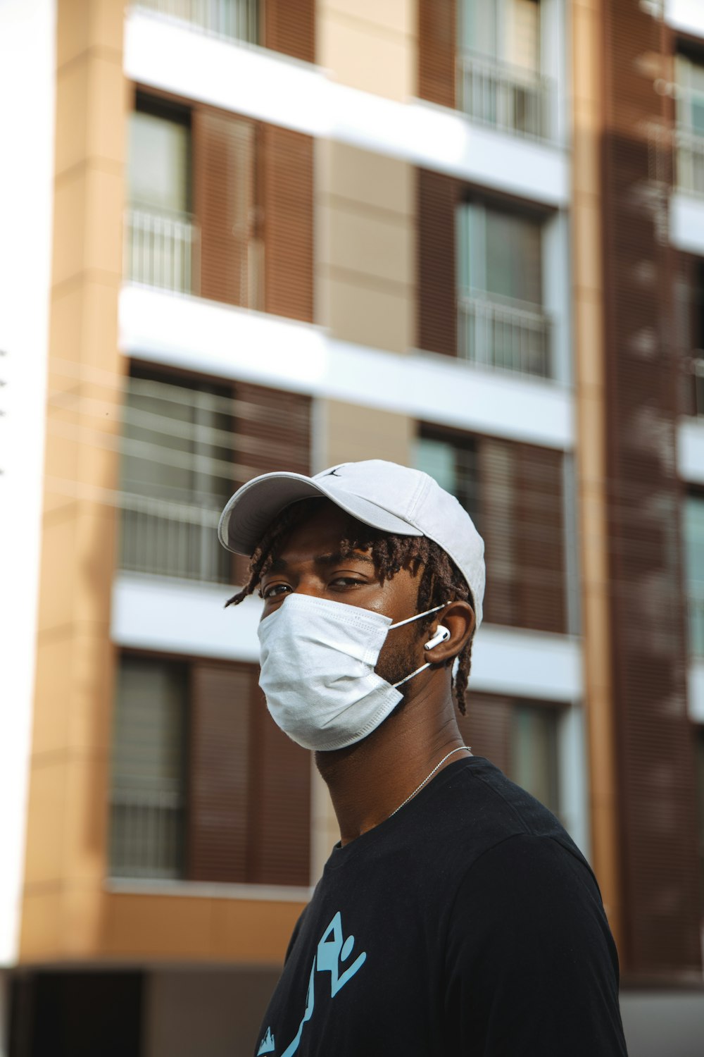 man in black crew neck shirt wearing white cap