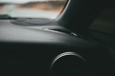 Close-up of a magnifying glass over a car dashboard, highlighting attention to detail.