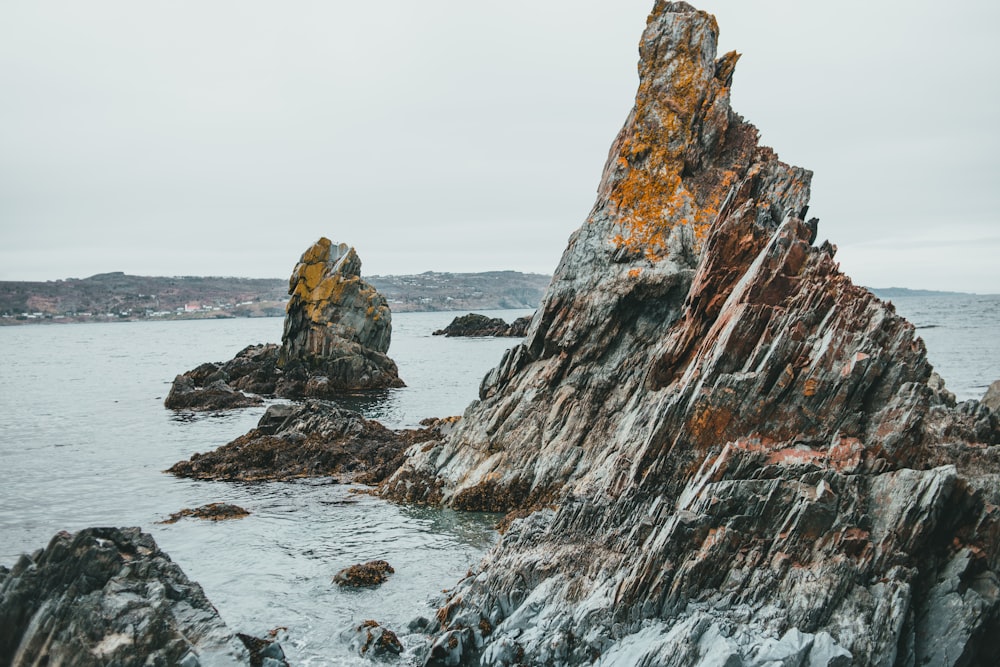 brown rock formation on sea water during daytime