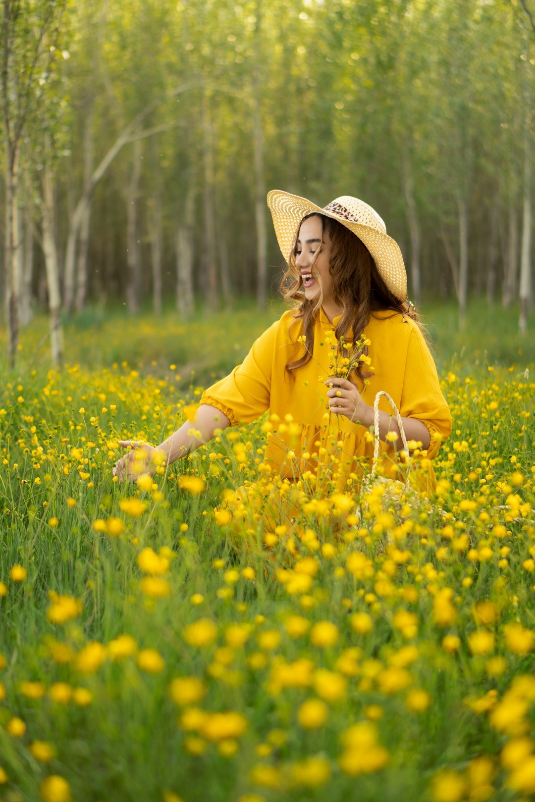 girl in yellow long sleeved shirt and brown cowboy hat standing on yellow flower field during