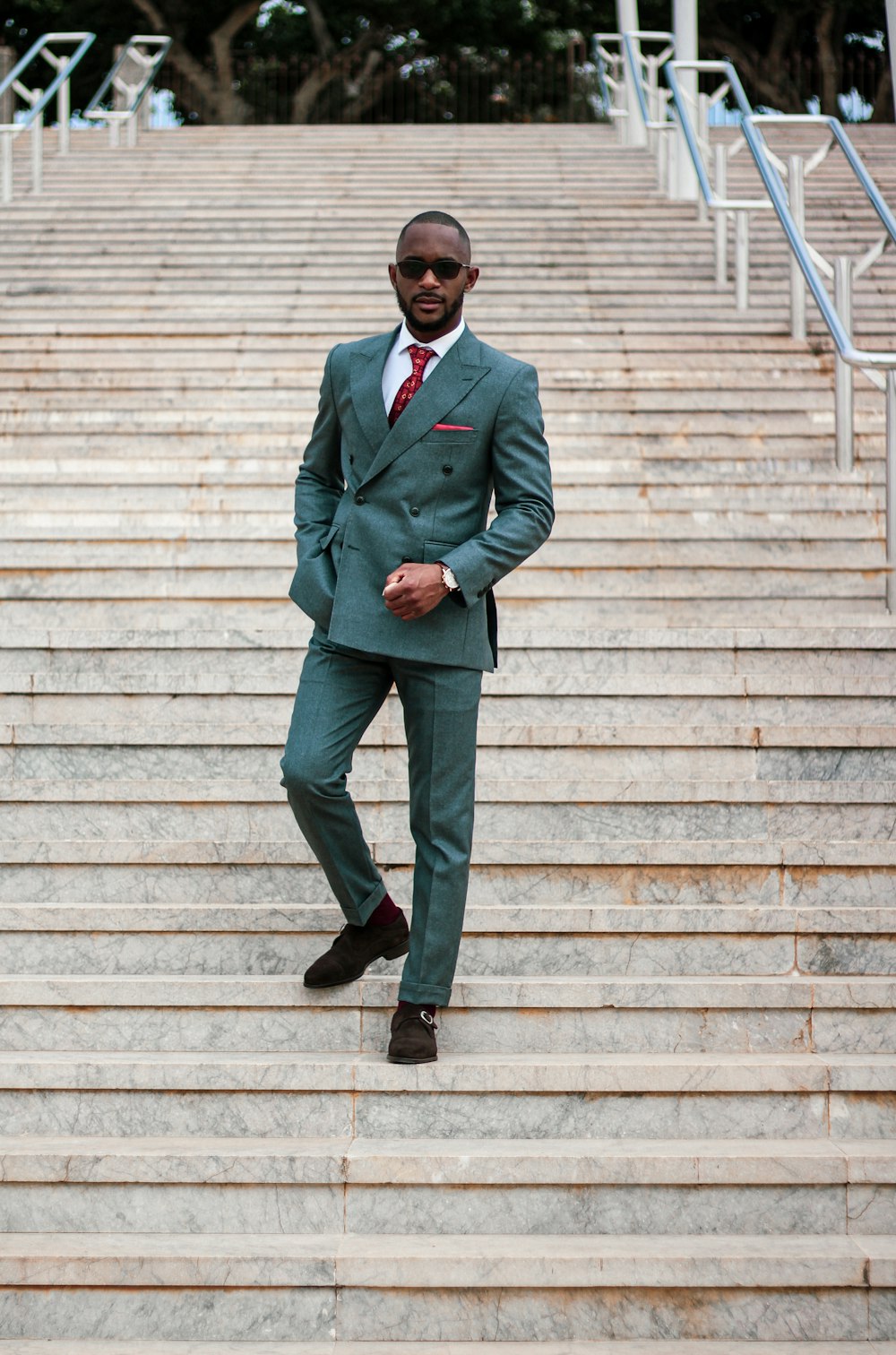 man in green suit standing on brown wooden stairs