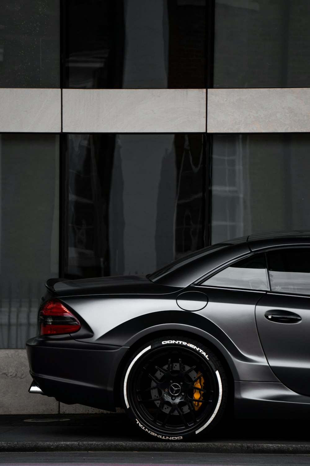 gray bmw m 3 coupe parked beside glass wall
