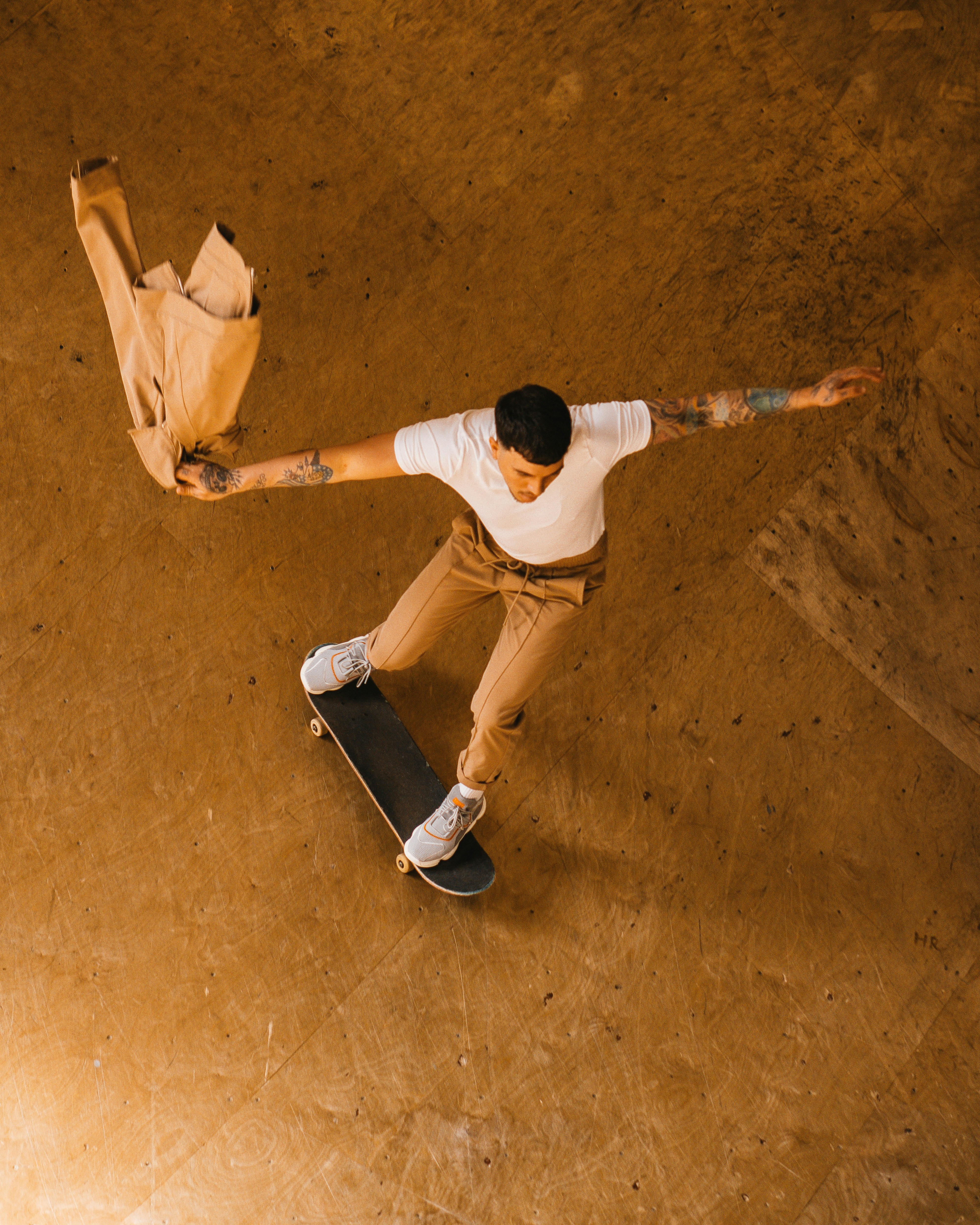 茶色のコンクリートの床に座っている白いシャツと白い短パンの女性