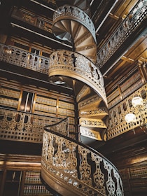 brown wooden spiral staircase with black metal railings