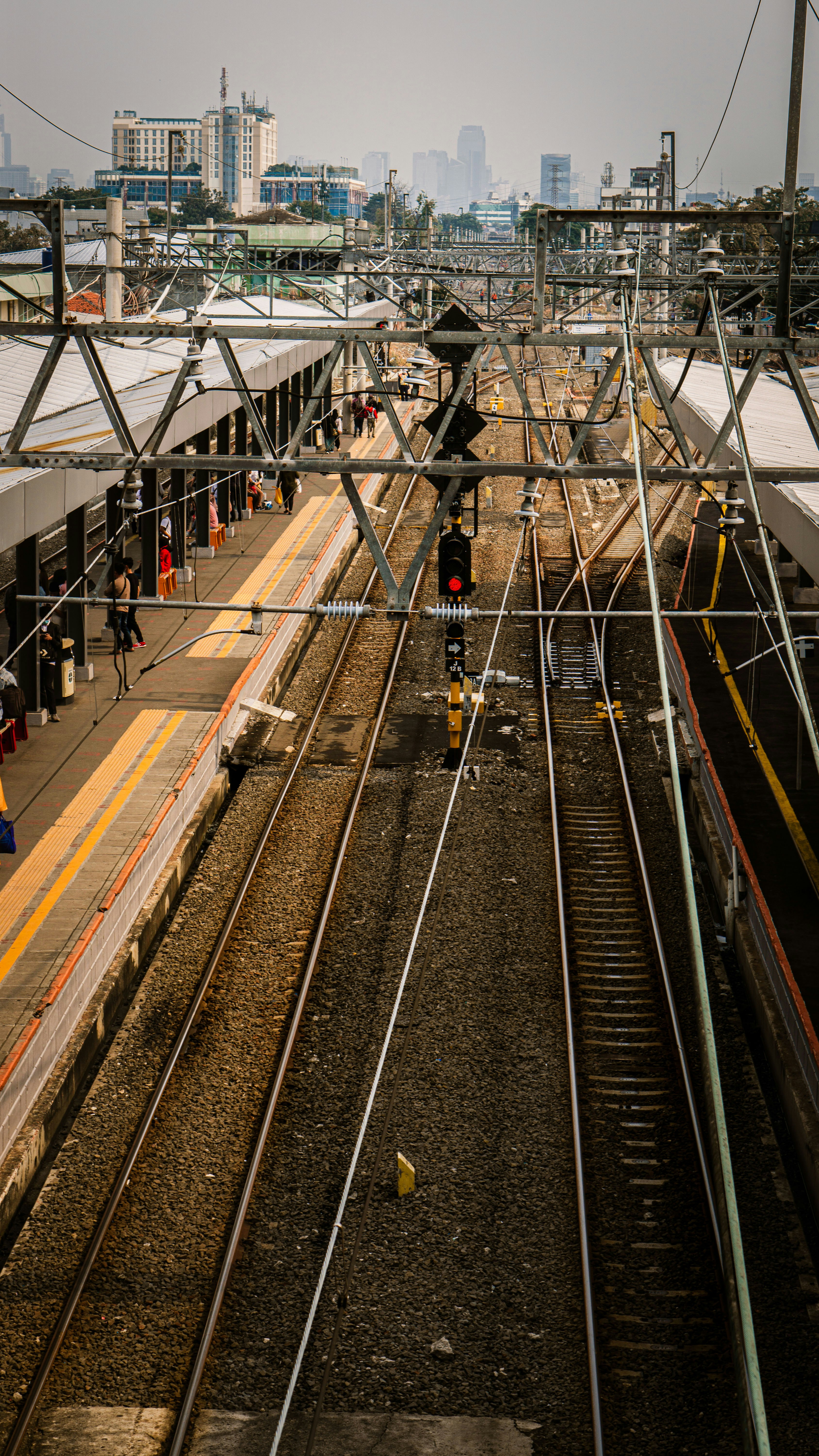 man in black jacket standing on train rail during daytime