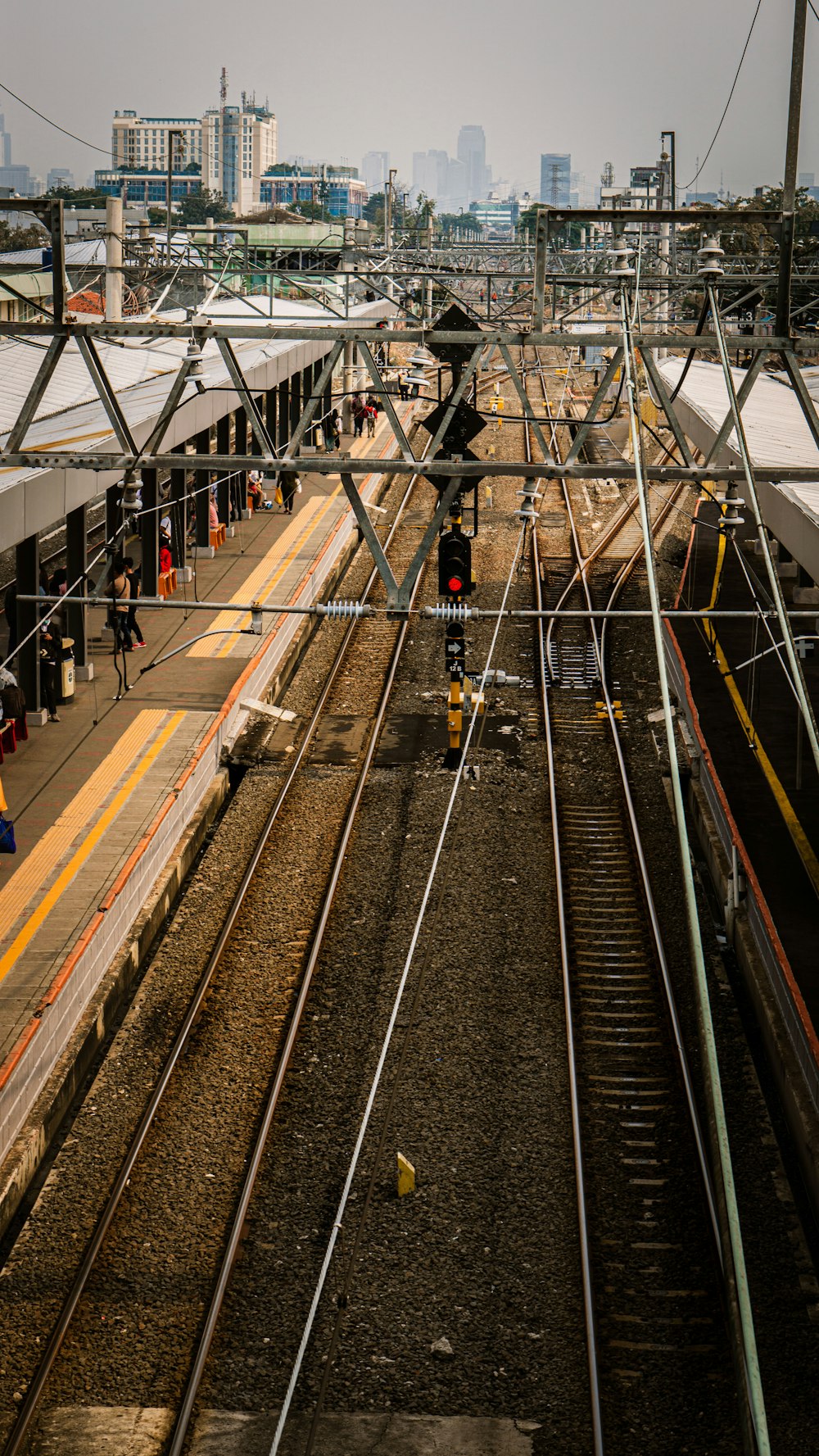 man in black jacket standing on train rail during daytime