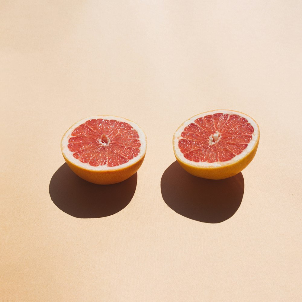 2 sliced orange fruit on white table