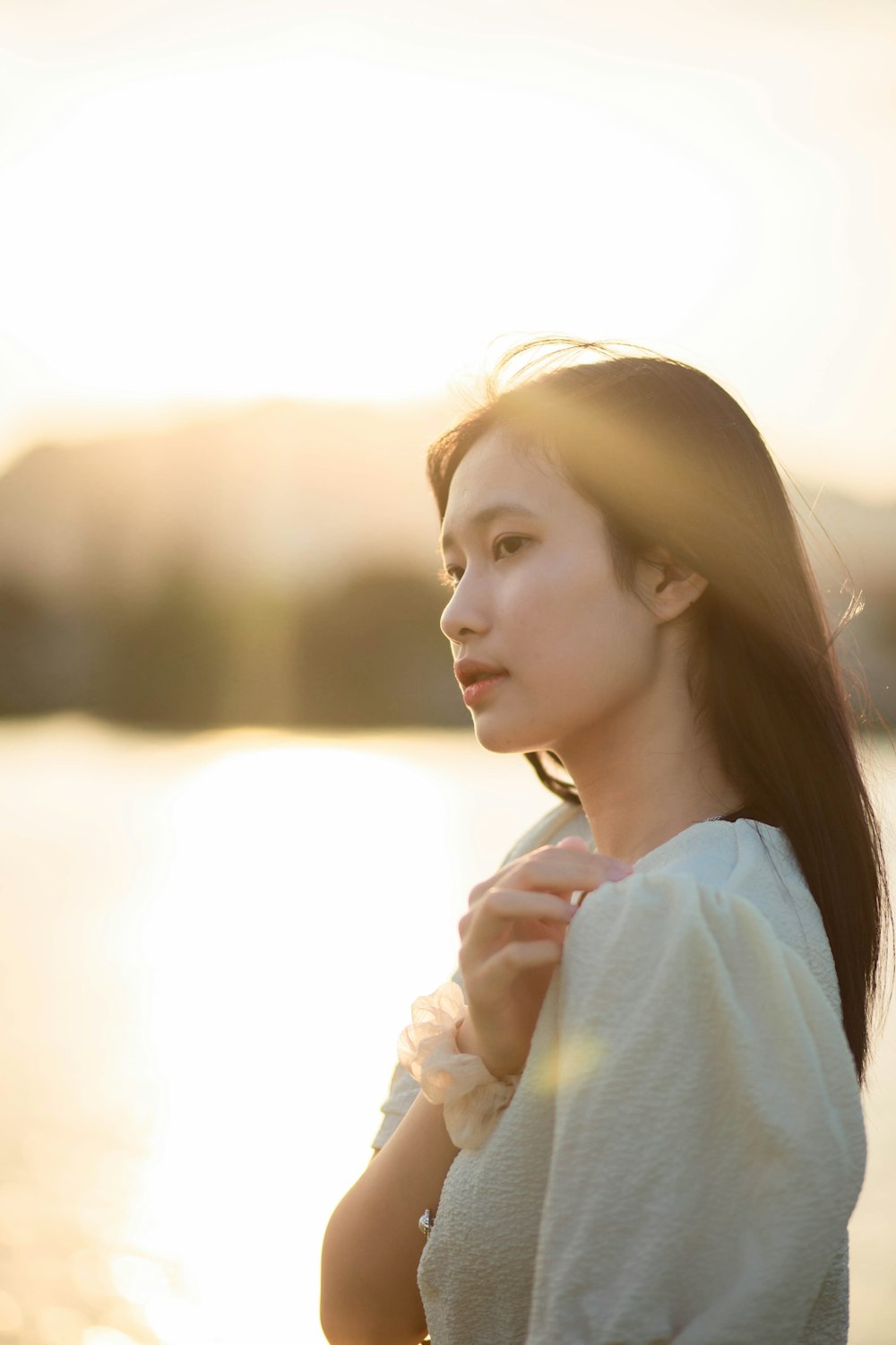 woman in white shirt with white flower on ear