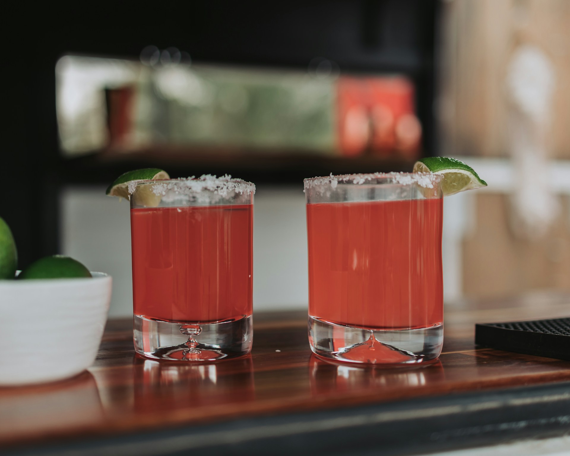 Two red cocktails with lime and salt look refreshing.