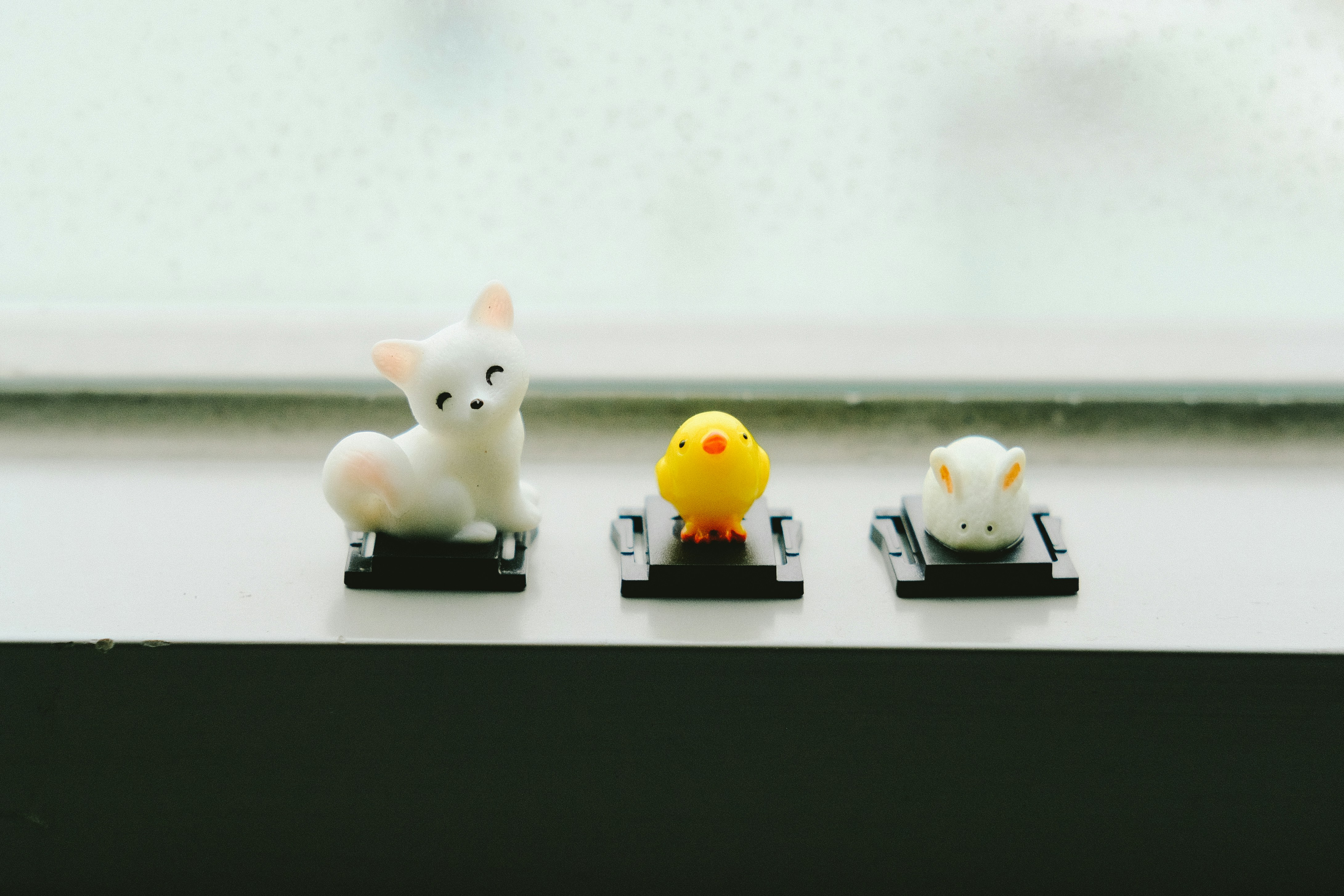 zwei weiße und gelbe Katzenfiguren