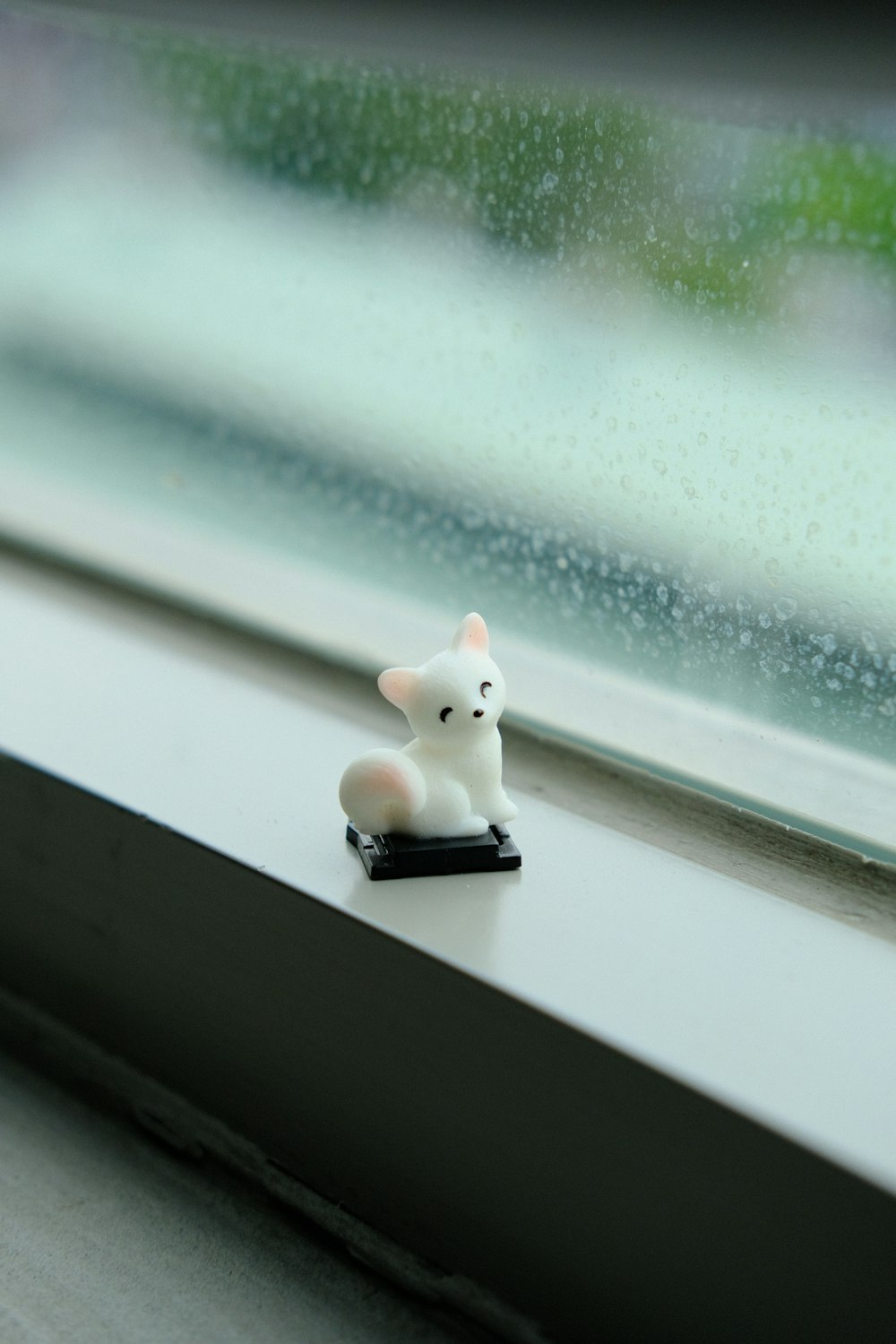 Figurine de chat blanc sur table blanche