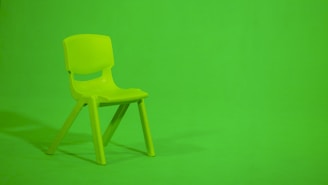 green plastic chair on green floor